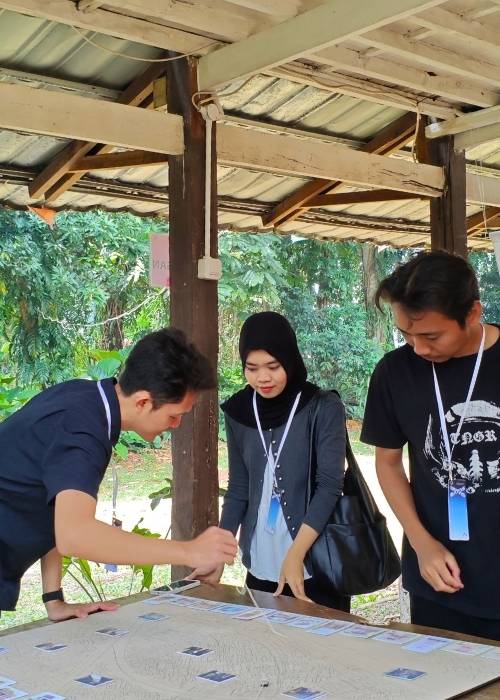 Maket interaktif dan poster program Kampung Gotong Royong Menteng Tenggulun kolaborasi IAI Jakarta x KemenPKP oleh YPA Architecture Studio di Bintaro Design District BDD 2026 Tanah Tinggal, menampilkan desain teknis Rumah Bapak Muslim oleh Ar. Yudha Prasetyo dan Rumah Ibu Mutiah oleh Ar. Titik Efianti & Ricky Geri Ariestivo.