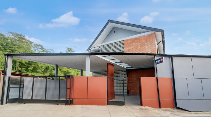 The facade of Rubina Hotel - Purbalingga with a mix of wood, stone, and glass materials, presents a modern tropical concept that is elegant and sustainable.