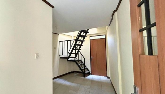 A sustainable urban housing project featuring compact modern residences, a pedestrian-friendly environment, and a landscaped public space with a pond and greenery. The area integrates eco-friendly elements such as green facades, vertical gardens, and natural ventilation.