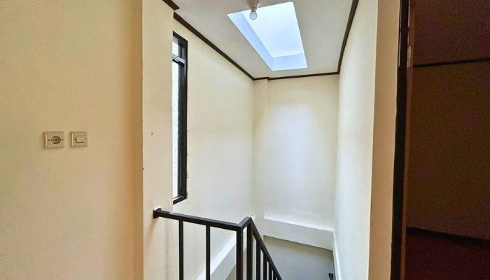 A sustainable urban housing project featuring compact modern residences, a pedestrian-friendly environment, and a landscaped public space with a pond and greenery. The area integrates eco-friendly elements such as green facades, vertical gardens, and natural ventilation.