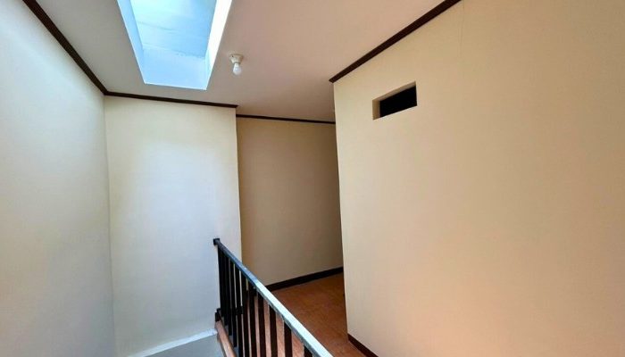 A sustainable urban housing project featuring compact modern residences, a pedestrian-friendly environment, and a landscaped public space with a pond and greenery. The area integrates eco-friendly elements such as green facades, vertical gardens, and natural ventilation.