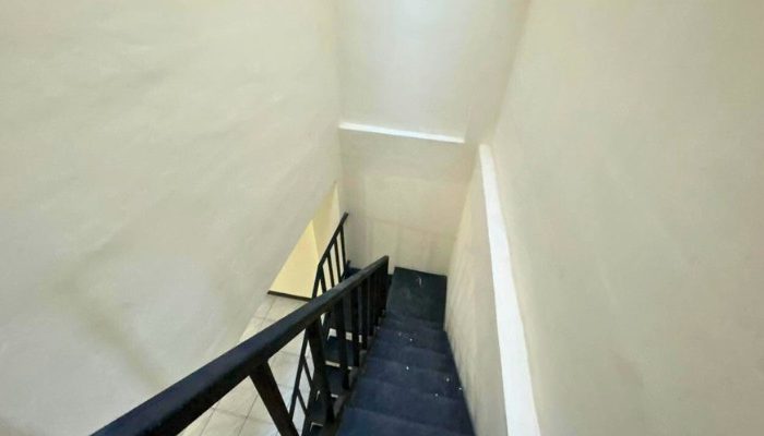 A sustainable urban housing project featuring compact modern residences, a pedestrian-friendly environment, and a landscaped public space with a pond and greenery. The area integrates eco-friendly elements such as green facades, vertical gardens, and natural ventilation.