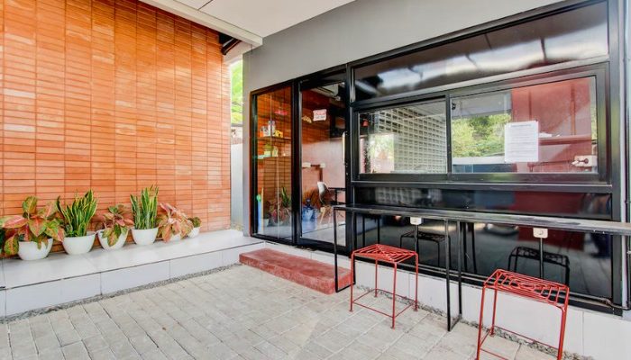 The facade of Rubina Hotel - Purbalingga with a mix of wood, stone, and glass materials, presents a modern tropical concept that is elegant and sustainable.