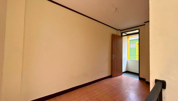 A sustainable urban housing project featuring compact modern residences, a pedestrian-friendly environment, and a landscaped public space with a pond and greenery. The area integrates eco-friendly elements such as green facades, vertical gardens, and natural ventilation.