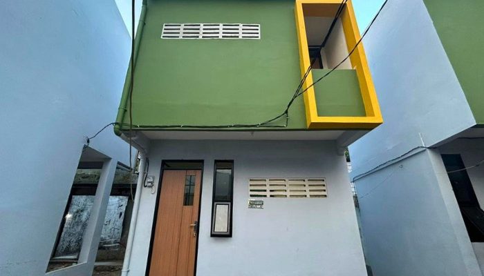 A sustainable urban housing project featuring compact modern residences, a pedestrian-friendly environment, and a landscaped public space with a pond and greenery. The area integrates eco-friendly elements such as green facades, vertical gardens, and natural ventilation.