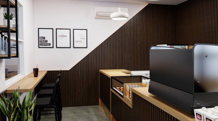The interior of Cafe Difabis features a modern and inclusive design, incorporating wood elements and warm lighting. The ergonomic barista area is designed for accessibility, showcasing a professional coffee machine, open storage shelves, and a well-organized food display.