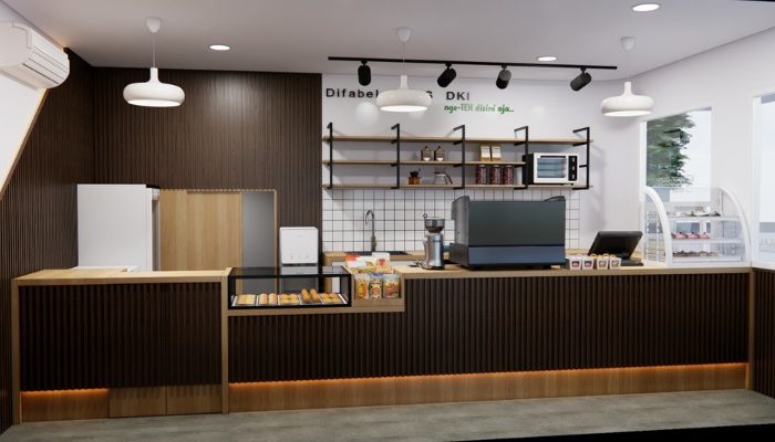 The interior of Cafe Difabis features a modern and inclusive design, incorporating wood elements and warm lighting. The ergonomic barista area is designed for accessibility, showcasing a professional coffee machine, open storage shelves, and a well-organized food display.