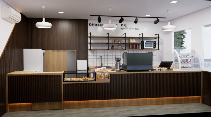 The interior of Cafe Difabis features a modern and inclusive design, incorporating wood elements and warm lighting. The ergonomic barista area is designed for accessibility, showcasing a professional coffee machine, open storage shelves, and a well-organized food display.