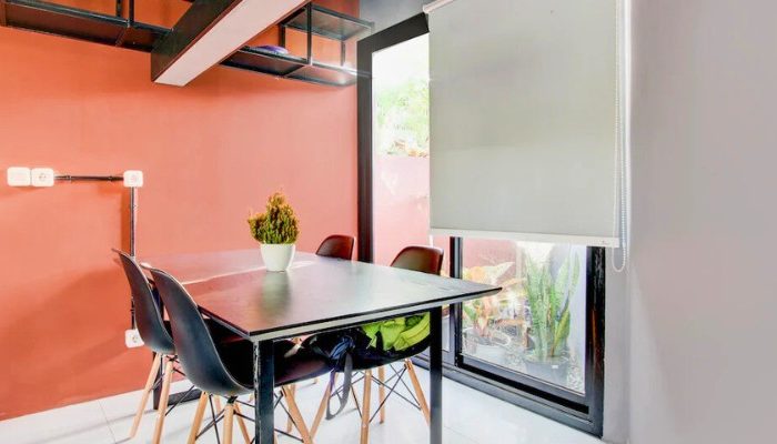 The facade of Rubina Hotel - Purbalingga with a mix of wood, stone, and glass materials, presents a modern tropical concept that is elegant and sustainable.