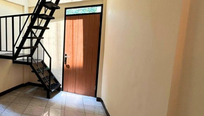 A sustainable urban housing project featuring compact modern residences, a pedestrian-friendly environment, and a landscaped public space with a pond and greenery. The area integrates eco-friendly elements such as green facades, vertical gardens, and natural ventilation.