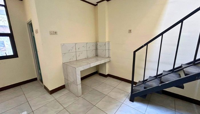 A sustainable urban housing project featuring compact modern residences, a pedestrian-friendly environment, and a landscaped public space with a pond and greenery. The area integrates eco-friendly elements such as green facades, vertical gardens, and natural ventilation.