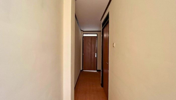 A sustainable urban housing project featuring compact modern residences, a pedestrian-friendly environment, and a landscaped public space with a pond and greenery. The area integrates eco-friendly elements such as green facades, vertical gardens, and natural ventilation.