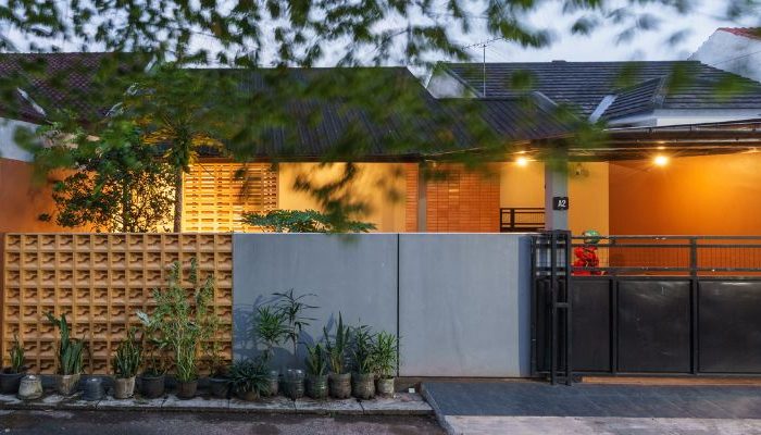 A modern tropical house with lattice walls, a green garden, and natural lighting in Purbalingga, designed by YPA Architecture Studio in 2024.