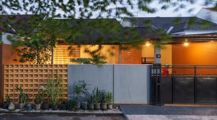 A modern tropical house with lattice walls, a green garden, and natural lighting in Purbalingga, designed by YPA Architecture Studio in 2024.