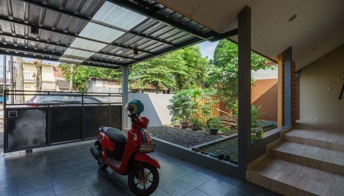 A modern tropical house with lattice walls, a green garden, and natural lighting in Purbalingga, designed by YPA Architecture Studio in 2024.