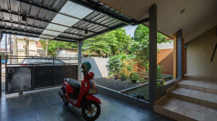 A modern tropical house with lattice walls, a green garden, and natural lighting in Purbalingga, designed by YPA Architecture Studio in 2024.