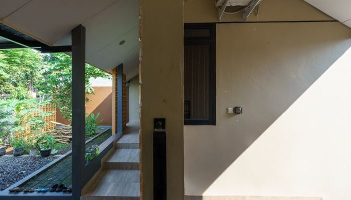 A modern tropical house with lattice walls, a green garden, and natural lighting in Purbalingga, designed by YPA Architecture Studio in 2024.