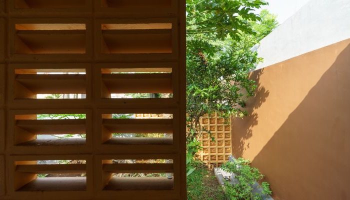 A modern tropical house with lattice walls, a green garden, and natural lighting in Purbalingga, designed by YPA Architecture Studio in 2024.