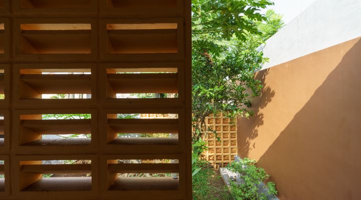 A modern tropical house with lattice walls, a green garden, and natural lighting in Purbalingga, designed by YPA Architecture Studio in 2024.