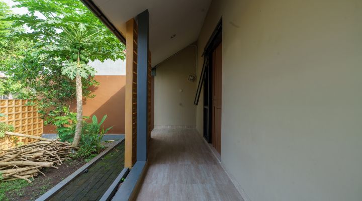 A modern tropical house with lattice walls, a green garden, and natural lighting in Purbalingga, designed by YPA Architecture Studio in 2024.