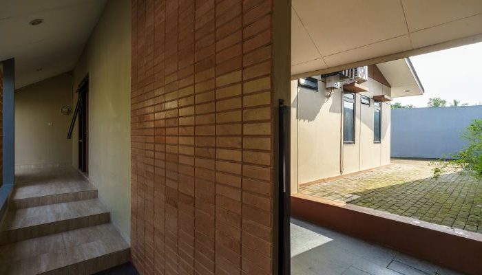 A modern tropical house with lattice walls, a green garden, and natural lighting in Purbalingga, designed by YPA Architecture Studio in 2024.