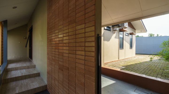 A modern tropical house with lattice walls, a green garden, and natural lighting in Purbalingga, designed by YPA Architecture Studio in 2024.