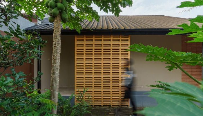 A modern tropical house with lattice walls, a green garden, and natural lighting in Purbalingga, designed by YPA Architecture Studio in 2024.