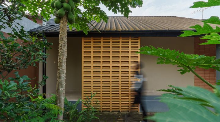 A modern tropical house with lattice walls, a green garden, and natural lighting in Purbalingga, designed by YPA Architecture Studio in 2024.