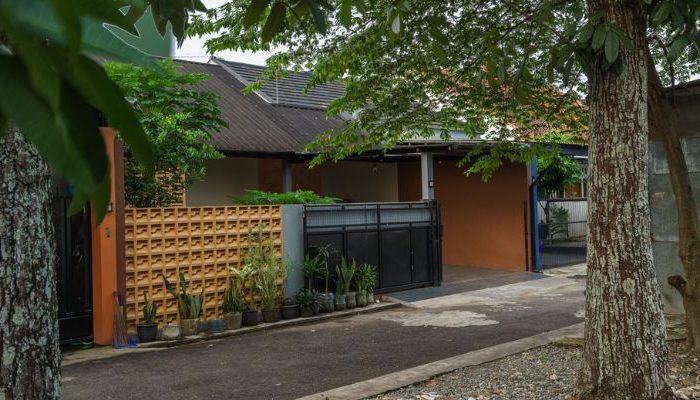 A modern tropical house with lattice walls, a green garden, and natural lighting in Purbalingga, designed by YPA Architecture Studio in 2024.