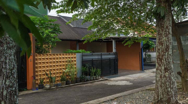 A modern tropical house with lattice walls, a green garden, and natural lighting in Purbalingga, designed by YPA Architecture Studio in 2024.