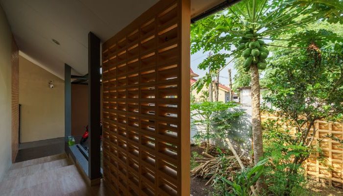 A modern tropical house with lattice walls, a green garden, and natural lighting in Purbalingga, designed by YPA Architecture Studio in 2024.