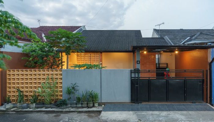 A modern tropical house with lattice walls, a green garden, and natural lighting in Purbalingga, designed by YPA Architecture Studio in 2024.