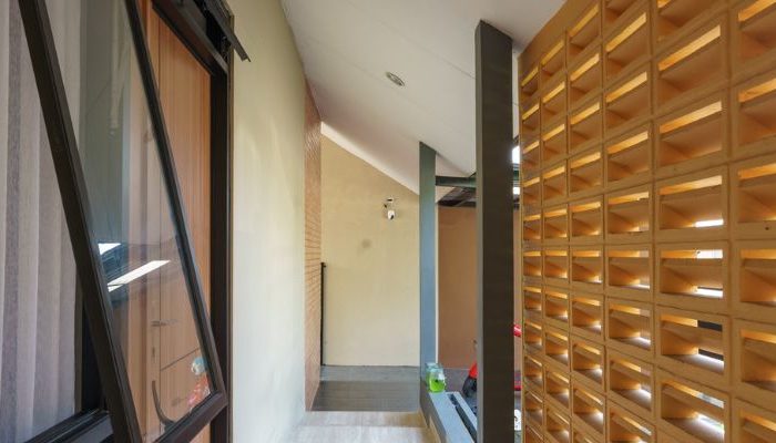A modern tropical house with lattice walls, a green garden, and natural lighting in Purbalingga, designed by YPA Architecture Studio in 2024.