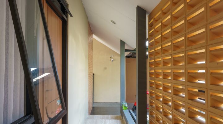 A modern tropical house with lattice walls, a green garden, and natural lighting in Purbalingga, designed by YPA Architecture Studio in 2024.
