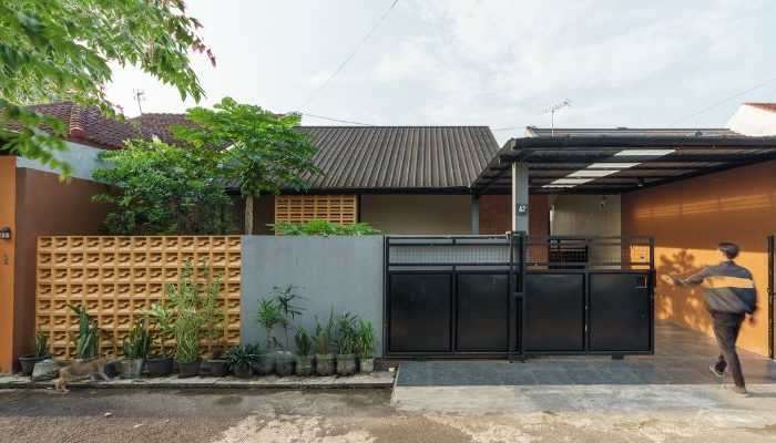 A modern tropical house with lattice walls, a green garden, and natural lighting in Purbalingga, designed by YPA Architecture Studio in 2024.