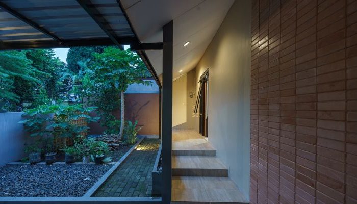 A modern tropical house with lattice walls, a green garden, and natural lighting in Purbalingga, designed by YPA Architecture Studio in 2024.