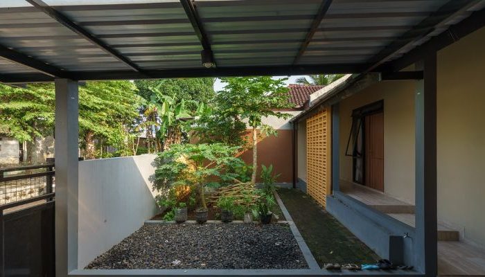 A modern tropical house with lattice walls, a green garden, and natural lighting in Purbalingga, designed by YPA Architecture Studio in 2024.