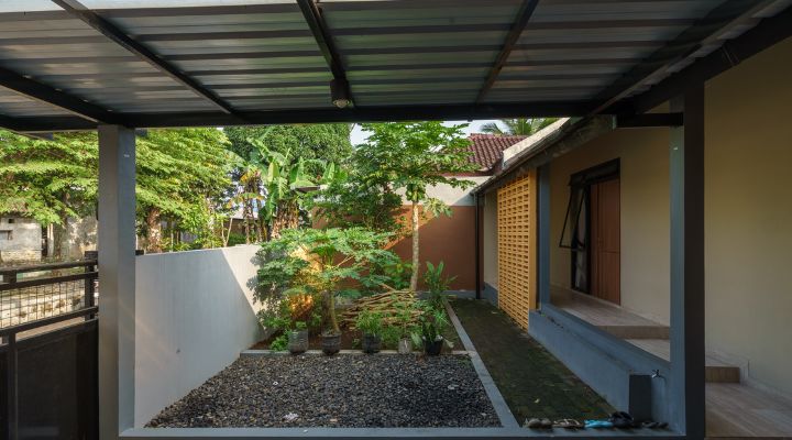 A modern tropical house with lattice walls, a green garden, and natural lighting in Purbalingga, designed by YPA Architecture Studio in 2024.