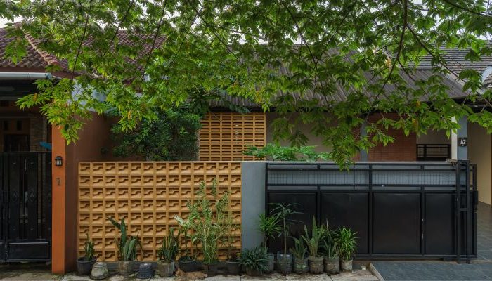 A modern tropical house with lattice walls, a green garden, and natural lighting in Purbalingga, designed by YPA Architecture Studio in 2024.