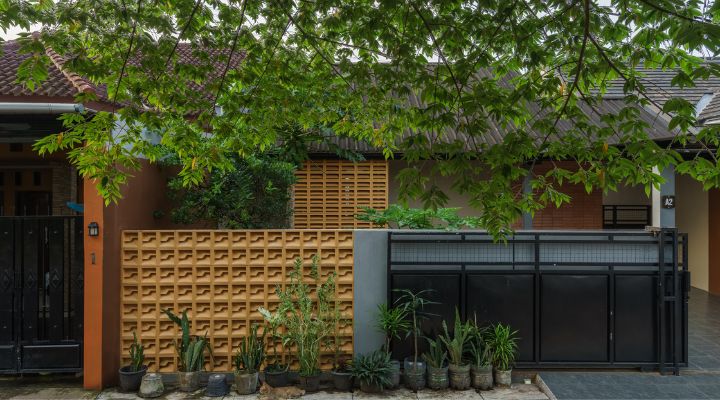 A modern tropical house with lattice walls, a green garden, and natural lighting in Purbalingga, designed by YPA Architecture Studio in 2024.