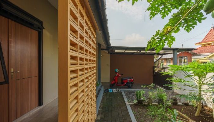A modern tropical house with lattice walls, a green garden, and natural lighting in Purbalingga, designed by YPA Architecture Studio in 2024.