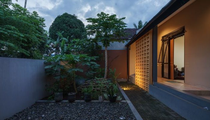 A modern tropical house with lattice walls, a green garden, and natural lighting in Purbalingga, designed by YPA Architecture Studio in 2024.
