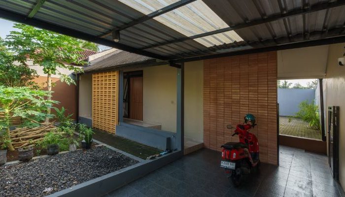 A modern tropical house with lattice walls, a green garden, and natural lighting in Purbalingga, designed by YPA Architecture Studio in 2024.