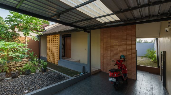 A modern tropical house with lattice walls, a green garden, and natural lighting in Purbalingga, designed by YPA Architecture Studio in 2024.