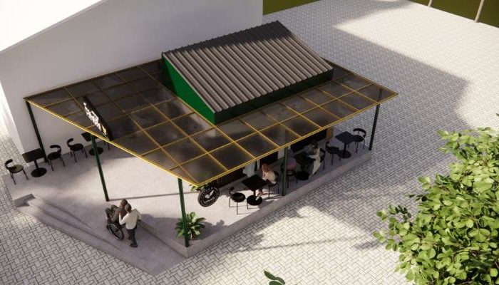 The exterior and interior design of Cafe Difabis RSUD Kebayoran Lama by YPA Architecture Studio features a small building with a transparent canopy, open seating area, and inclusive layout that is disability friendly.