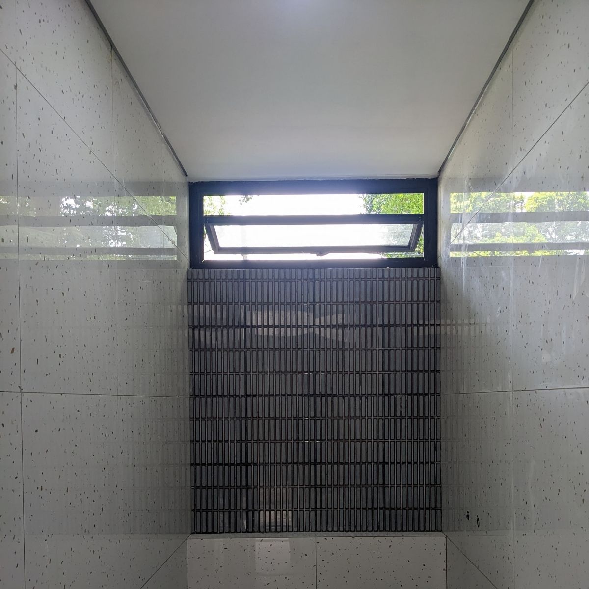 Proyek Adhara House di Tangerang Selatan karya YPA Architecture Studio dan Barakaja Construction menampilkan fasad modern dengan aksen merah, dinding roster beton, dan inner courtyard minimalis dengan kolam air yang terintegrasi dengan interior rumah yang luas.