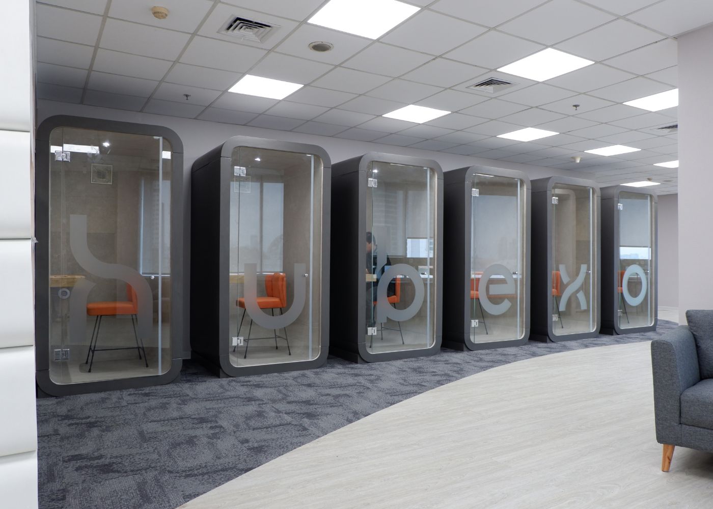 Interior kantor modern Hubexo di Jakarta Selatan karya YPA Architecture Studio dan Barakaja Construction menampilkan area kolaborasi dengan meeting pod privat, pantry minimalis hijau sage, ruang rapat formal, serta lounge komunal yang luas dengan pencahayaan alami.