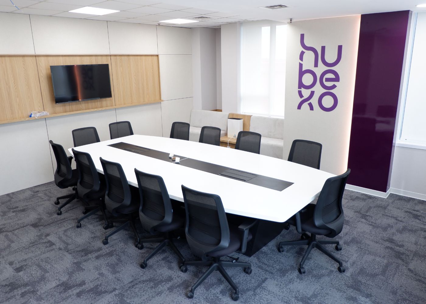 Interior kantor modern Hubexo di Jakarta Selatan karya YPA Architecture Studio dan Barakaja Construction menampilkan area kolaborasi dengan meeting pod privat, pantry minimalis hijau sage, ruang rapat formal, serta lounge komunal yang luas dengan pencahayaan alami.