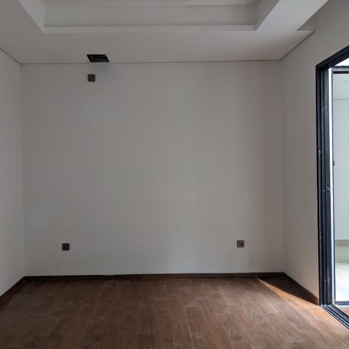 Proyek Adhara House di Tangerang Selatan karya YPA Architecture Studio dan Barakaja Construction menampilkan fasad modern dengan aksen merah, dinding roster beton, dan inner courtyard minimalis dengan kolam air yang terintegrasi dengan interior rumah yang luas.