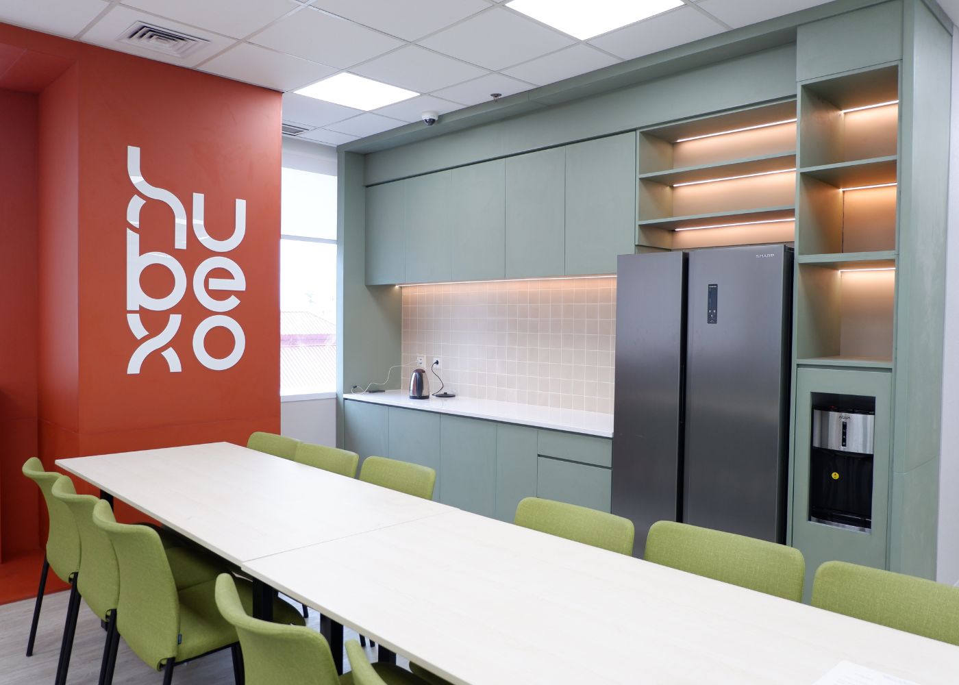 Interior kantor modern Hubexo di Jakarta Selatan karya YPA Architecture Studio dan Barakaja Construction menampilkan area kolaborasi dengan meeting pod privat, pantry minimalis hijau sage, ruang rapat formal, serta lounge komunal yang luas dengan pencahayaan alami.
